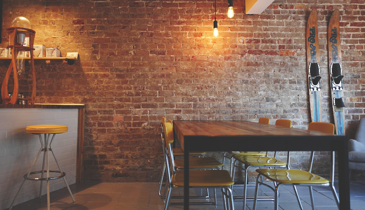 Modernes leeres Restaurant mit rustikaler Backsteinwand