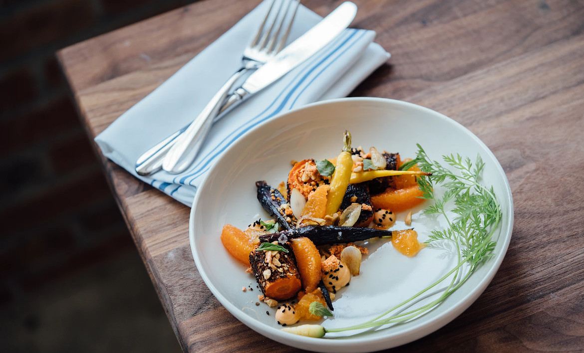Modern angerichtetes Fine-Dining-Gericht mit Gemüse auf einem Restaurantteller